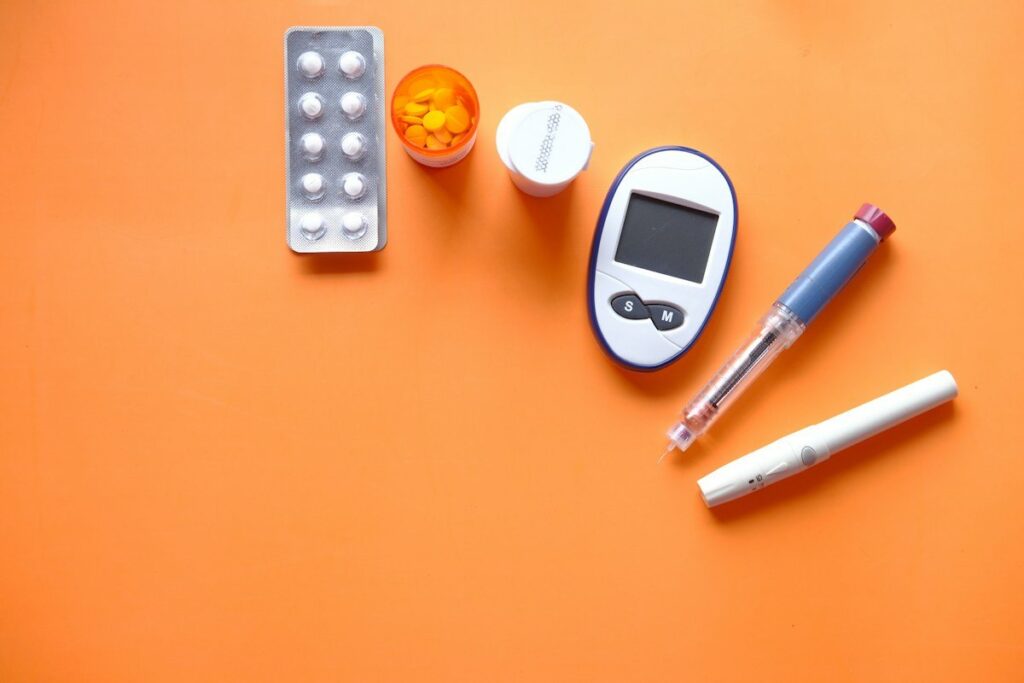A blood glucose meter beside testing supplies