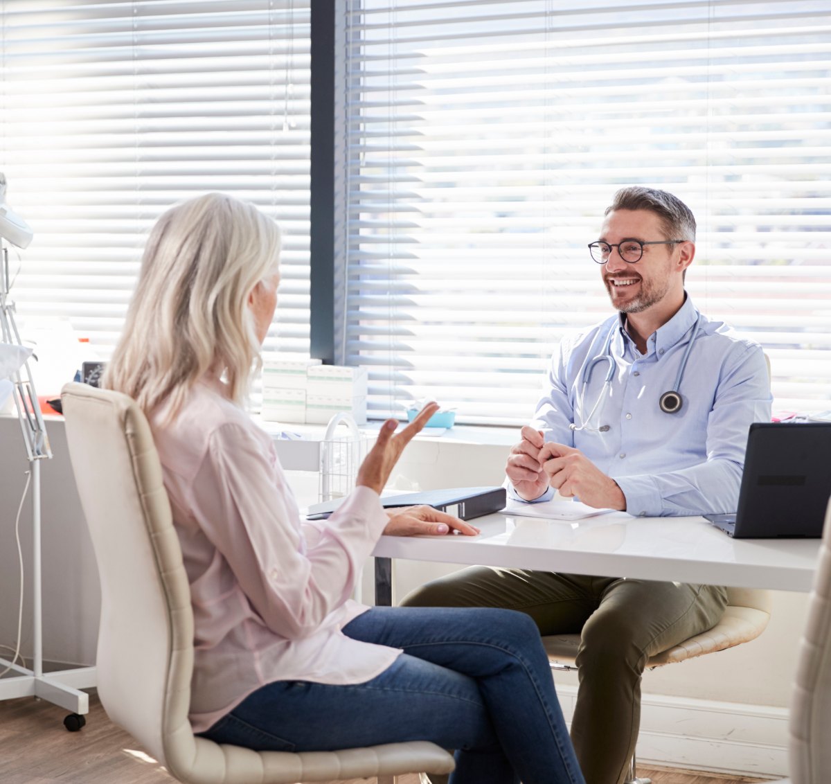 A patient talking with a smiling doctor during a consultation